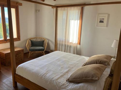 a bedroom with a bed and a chair and a window at Es Campet, charmante finca, Soller, Vue splendide, piscine, calme in Sóller