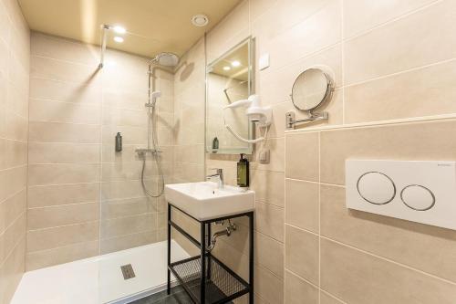 a bathroom with a sink and a shower at Hotel 't Putje in Bruges