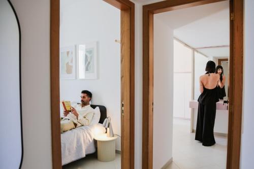 a man sitting in a chair next to a woman in a mirror at Palazzo Marzionna in Polignano a Mare