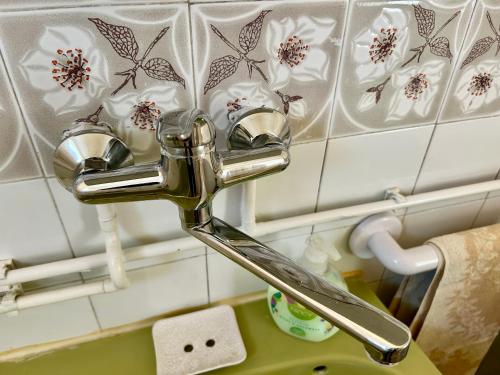 a bathroom sink with a chrome faucet at Rózsa Ház in Mélykút