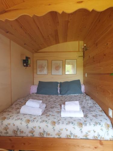 a bedroom with a bed with two towels on it at Roulotte bohème in Chazelles