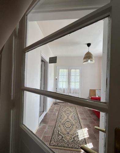 a view through a window of a room with a rug at Rózsa Ház in Mélykút