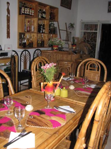 a wooden table with flowers and glasses on it at Avamada Lodge in Ivato