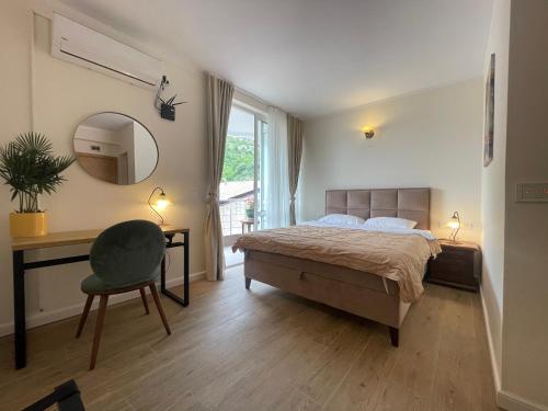 a bedroom with a bed and a desk and a mirror at Guest house Villa Slavica in Sveti Stefan