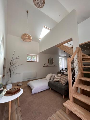 a living room with a bed and a staircase at Ker Rev Home Gîte indépendant de charme en longère bretonne in Quimper