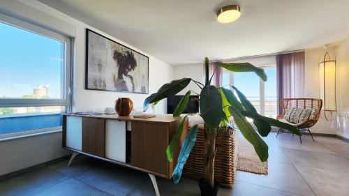 a living room with a table and a plant at A l'aube de Bali in Amnéville