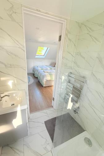 a bathroom with a sink and a bed and a mirror at Large 3 bed 2 bath modern apartment in Finchley