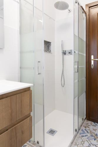a bathroom with a shower with a glass door at Casa Rica in Alghero