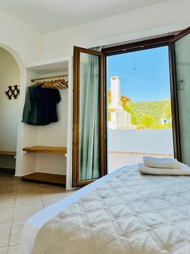 a bedroom with a bed and a large glass door at Limnes Seaside Combo in Ligaridia