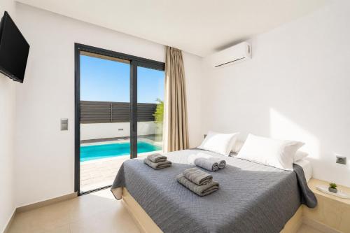 a bedroom with a bed and a view of the ocean at Villa Salty Sun 6 in Kremasti