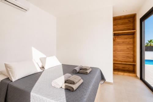 a bedroom with a bed with towels on it at Villa Salty Sun 6 in Kremasti