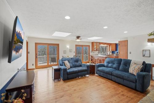 a living room with two blue couches and a kitchen at Vista Ridge at Alpine 4BDR in Jasper