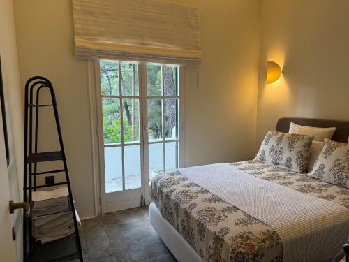 a bedroom with a bed and a ladder and a window at Villa Rhodos Skiathos in Skiathos