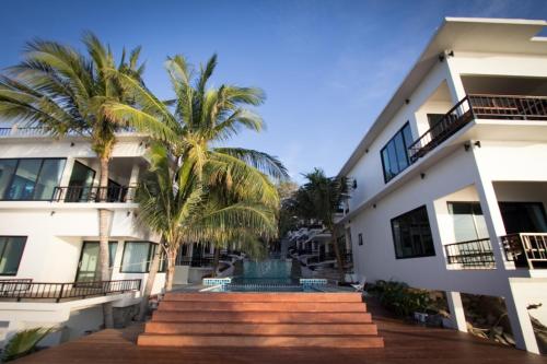a building with palm trees in front of it at Simple Life Cliff View Resort in Koh Tao