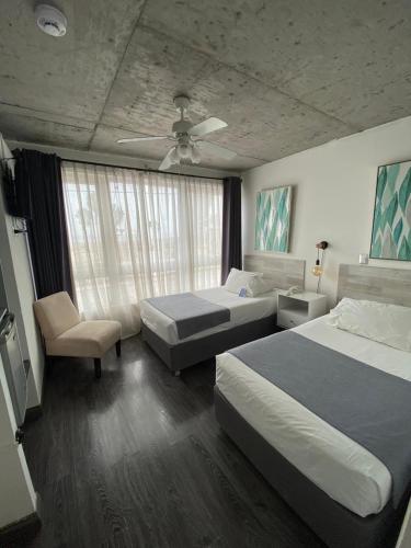 a bedroom with two beds and a ceiling fan at Hotel Puerto Chinchorro in Arica