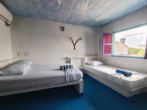 a bedroom with two beds and a window at Casa Violeta Beach House in Rincón