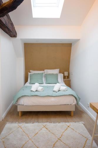 a bedroom with a bed with two towels on it at Le Grand Rue Signature - Appartement coeur de ville, rue piétonne in Bergerac