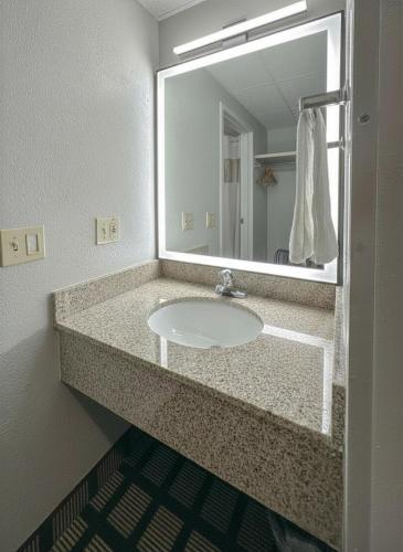 a bathroom with a sink and a large mirror at Baymont by Wyndham Queensbury/Lake George in Queensbury