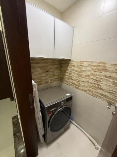 a small kitchen with a stove in a room at Taqah Beach Front Apartment in Ţāqah