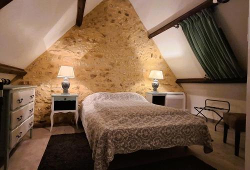 a bedroom with a bed and two tables and two lamps at Coquelicots Dordogne in Saint-Julien-de-Lampon