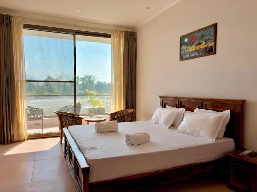 a bedroom with a large bed and a large window at Eternal Bliss By Ganga Blessing in Rishīkesh