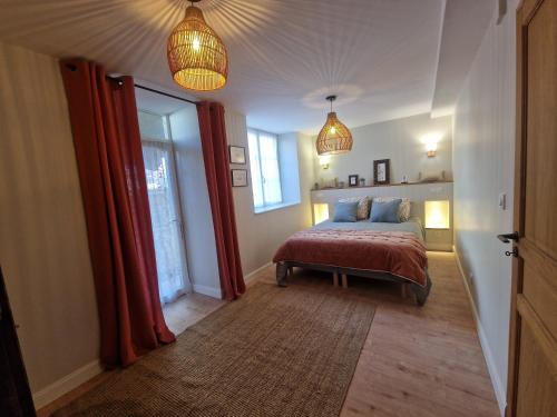 a bedroom with a bed with red curtains and two lights at Maison de Centre ville in Limoux