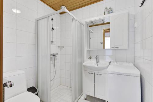 a white bathroom with a toilet and a sink at ÄkäsLuppo - Valkea Homes in Kittilä