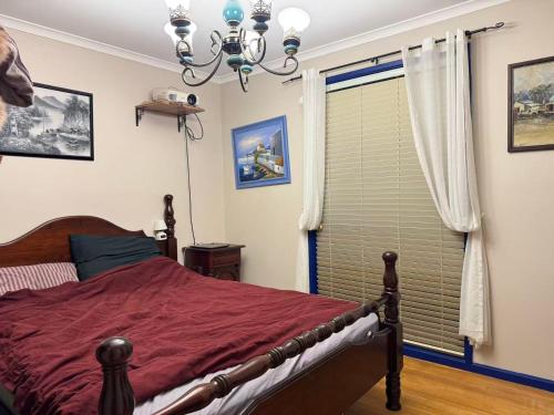 a bedroom with a bed with a red comforter and a window at Sweet home in Goodwin Hill in Macgregor
