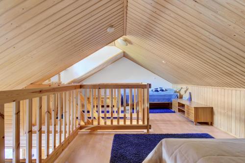 a attic bedroom with a bed and a staircase at ÄkäsLuppo - Valkea Homes in Kittilä