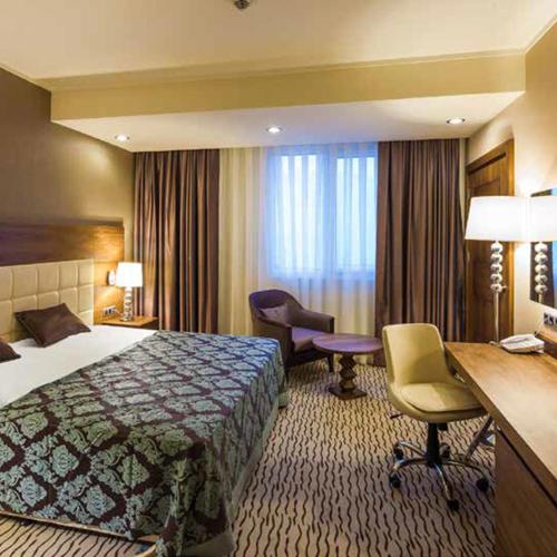 a hotel room with a bed and a desk at Crixus Hotels Duhok in Duhok