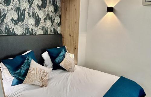 a bedroom with a bed with blue and white pillows at Villa Etoile in Cannes