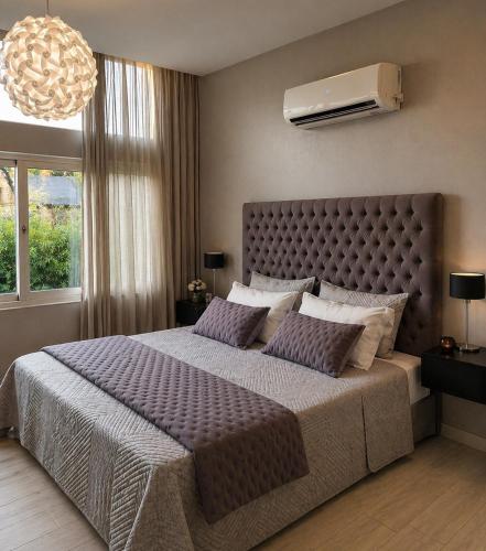 a bedroom with a large bed with purple pillows at Armonium Airport in Ezeiza