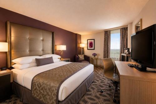 a hotel room with a bed and a desk and a television at DoubleTree by Hilton Orlando East - UCF Area in Orlando