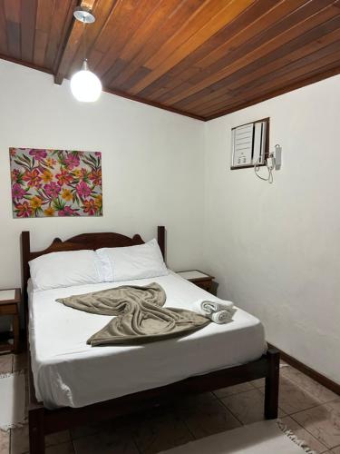 a bedroom with a bed with a blanket on it at Pousada céu azul Paraty in Paraty