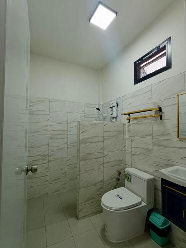 a white bathroom with a toilet and a shower at Home No 3 khanom in Ban Thung O