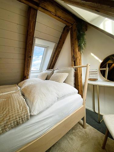 a bed in a room with a window at Zentrales Design Loft über den Dächern St Gallens in St. Gallen