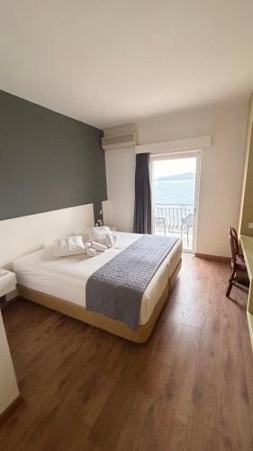 ein Schlafzimmer mit einem Bett und einem großen Fenster in der Unterkunft Annema Hotel and Restaurant in Monemvasia
