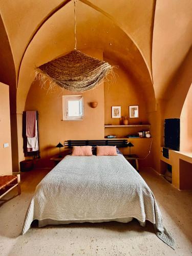 a bedroom with a bed in a room with an arched ceiling at Antica Masseria le Monache in Grottaglie