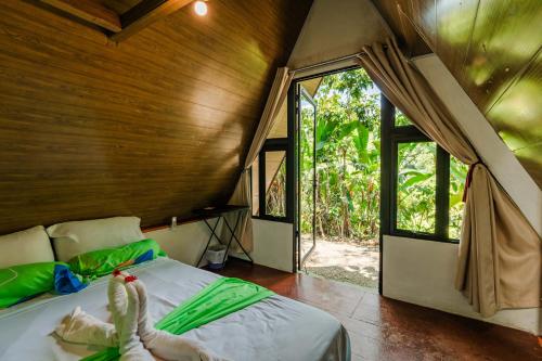 a bedroom with a bed in a room with windows at Chalets Silencio del Bosque in Fortuna
