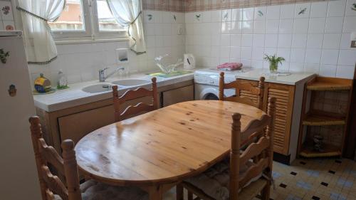 a kitchen with a wooden table and a sink at Marychris in Saint-Loubès