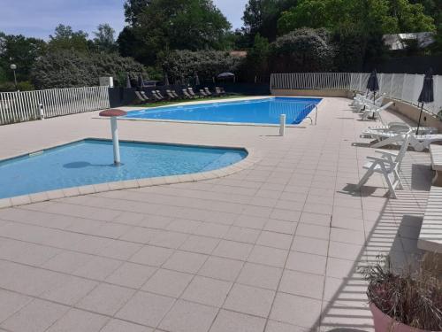 a large swimming pool with chairs at Mobil-home Moon River in Thiviers