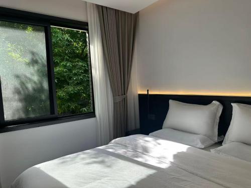 a bedroom with a bed and a large window at 璞宿清居民宿 in Xi'an