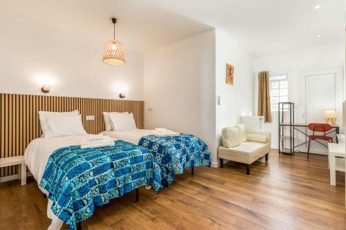 a hotel room with two beds and a chair at Learn Fun Madalena - Shared Swimming pool in Madalena