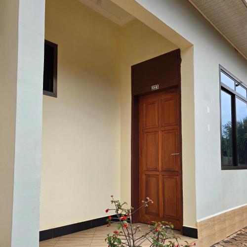 a house with a wooden door on the side at Kilimanjaro Magic MJ Branch in Old Moshi