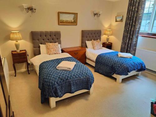 a bedroom with two beds with blue and white blankets at Bossington Bunkhouse in Minehead