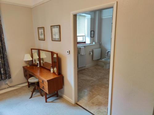 a bathroom with a wooden desk and a mirror at Bossington Bunkhouse in Minehead