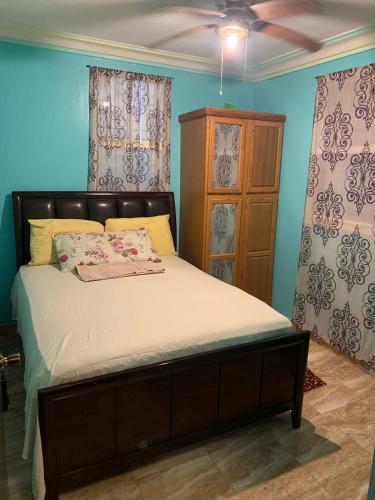 a bedroom with a bed and a dresser and curtains at Villa Simon Guest house in Les Cayes
