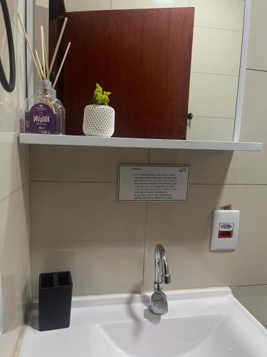 a sink in a bathroom with a mirror above it at Chale verde Aconchegante com lareira no bosque e estacionamento grátis in Extrema