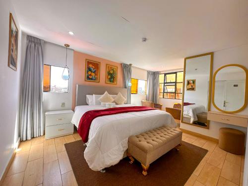 a bedroom with a large bed and a large mirror at Hotel Huaytapallana suites in Huancayo
