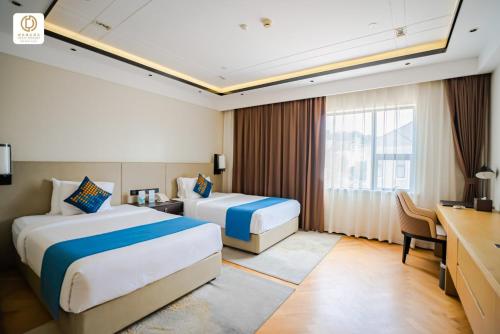 a hotel room with two beds and a desk at Ocean Delight Boutique Hotel 海悦精品酒店 in Sihanoukville